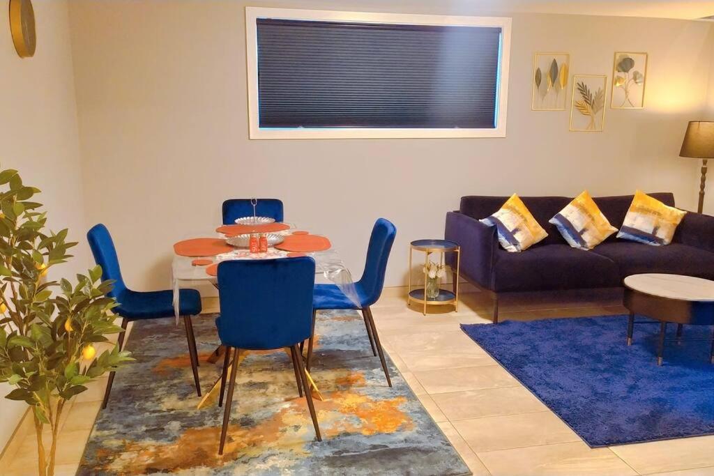 sala de estar con mesa, sillas y sofá en *Luxury 1 BR Suite - Own Access*, en Sherwood Park
