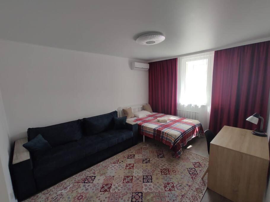 een woonkamer met een bank en een bed bij 1 комнатная квартира в ЖК Алмалы,район Алматы Арена in Alma-Ata