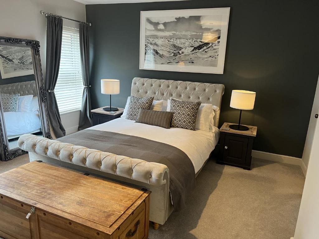 um quarto com uma cama grande e 2 candeeiros em Luxurious Victorian villa with parking sleeps six em Bury Saint Edmunds