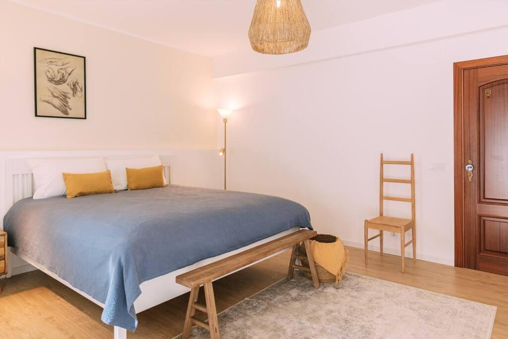 een slaapkamer met een bed met een blauwe deken en een ladder bij Starry Nights Apartment in Albufeira
