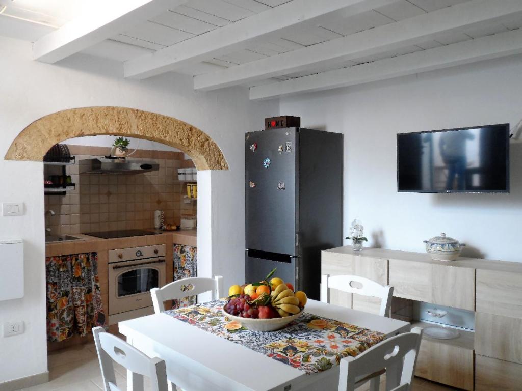 - une cuisine avec une table et un bol de fruits dans l'établissement Casa Bianca, à Gagliano del Capo