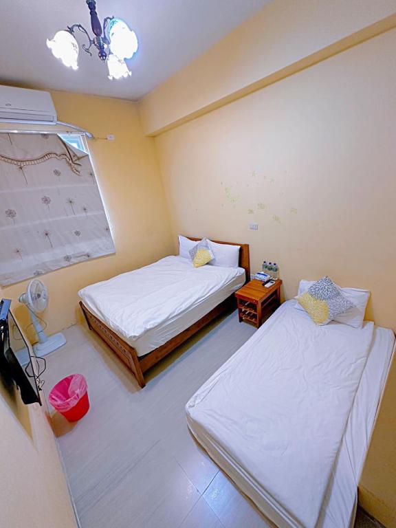 a small room with two beds and a table at 萩閣民宿Sara&#39;s House走路可到夜市近市區好停車 in Hualien City