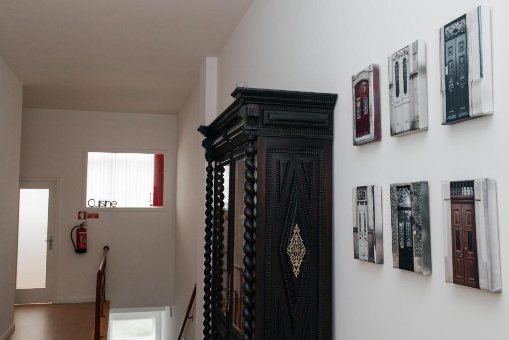 uno specchio nero su un muro con immagini di Júlio de Matos Guest House a Porto