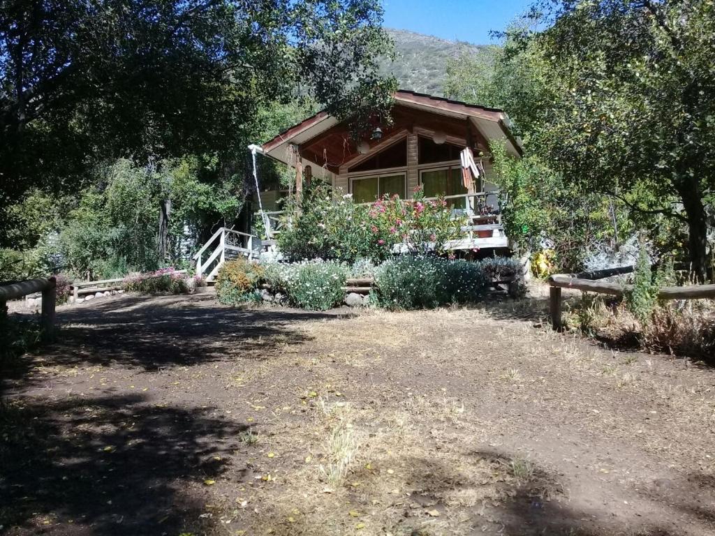 une cabane en rondins avec une terrasse couverte et une cour dans l'établissement Casa Alfalfal, à San José de Maipo