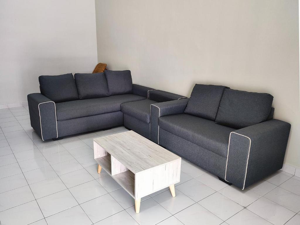 uma sala de estar com dois sofás e uma mesa de centro em Gaya Homestay 3Bed 2Bath 12pax Taman Gaya JB 5min to Aeon&Ikea 高雅民宿 em Ulu Tiram