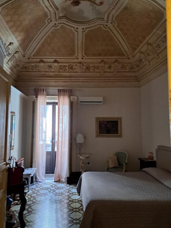 a bedroom with a bed and a coffered ceiling at Vera Rooms in Catania