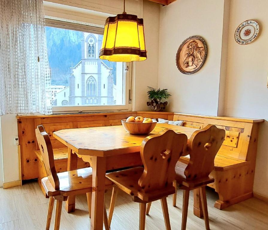 - une salle à manger avec une table et des chaises en bois dans l'établissement DolomiApartments - Casa Daria, à Predazzo