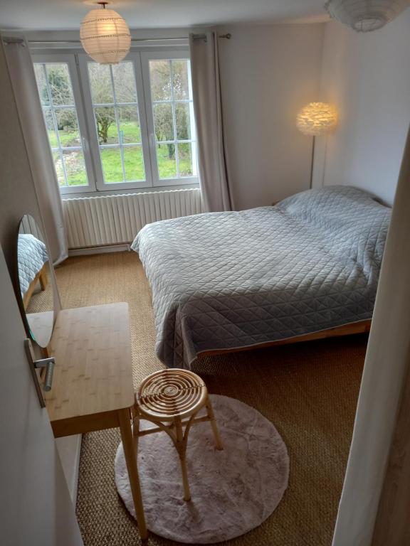 a bedroom with a bed and a chair and a table at Au bord du Vilpion in Marle-et-Behaine