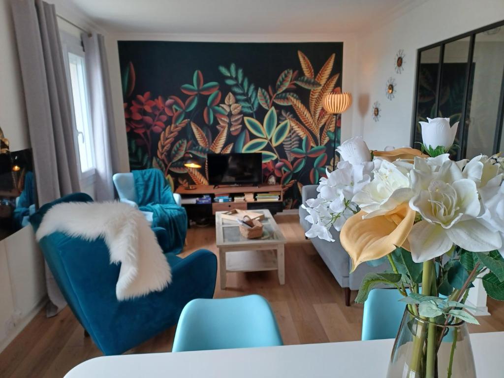 コンカルノーにあるappartement vue merのリビングルーム(青い椅子、花瓶付)