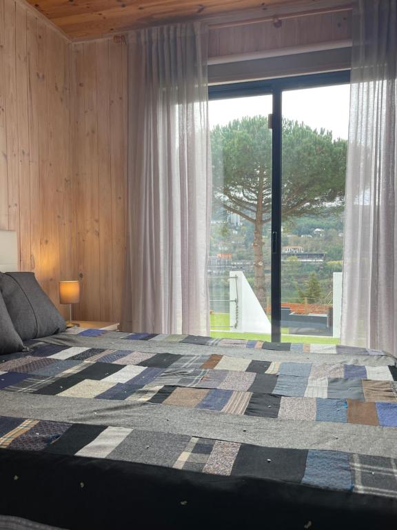 a bedroom with a bed and a large window at Douro in Melres