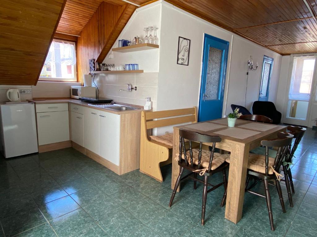 kuchnia i jadalnia ze stołem i krzesłami w obiekcie Kék Nefejelcs apartman w mieście Bükkszentkereszt