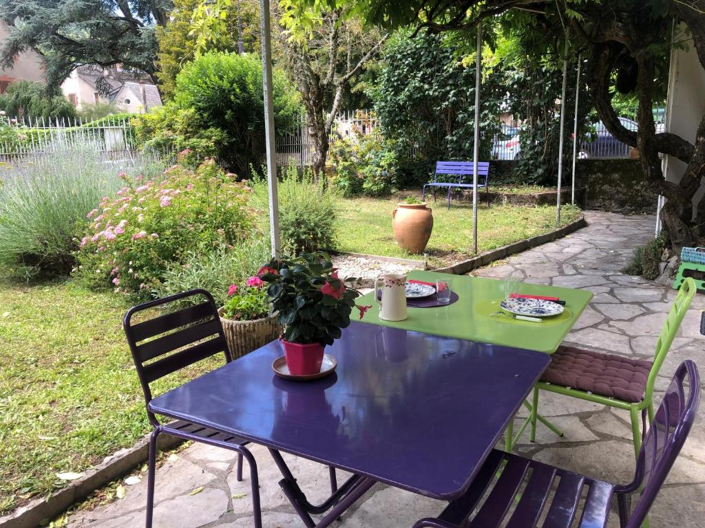 einen blauen Tisch und Stühle im Garten in der Unterkunft La Glycine in La Canourgue