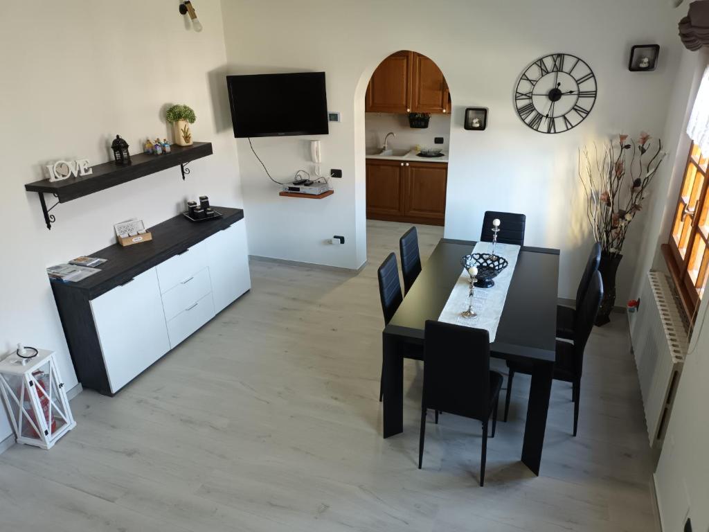 uma cozinha e sala de jantar com mesa e cadeiras em Maison de Denise em Lezzeno