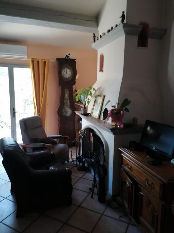 - un salon avec une cheminée et une horloge dans l'établissement Villa provençale, à Aups