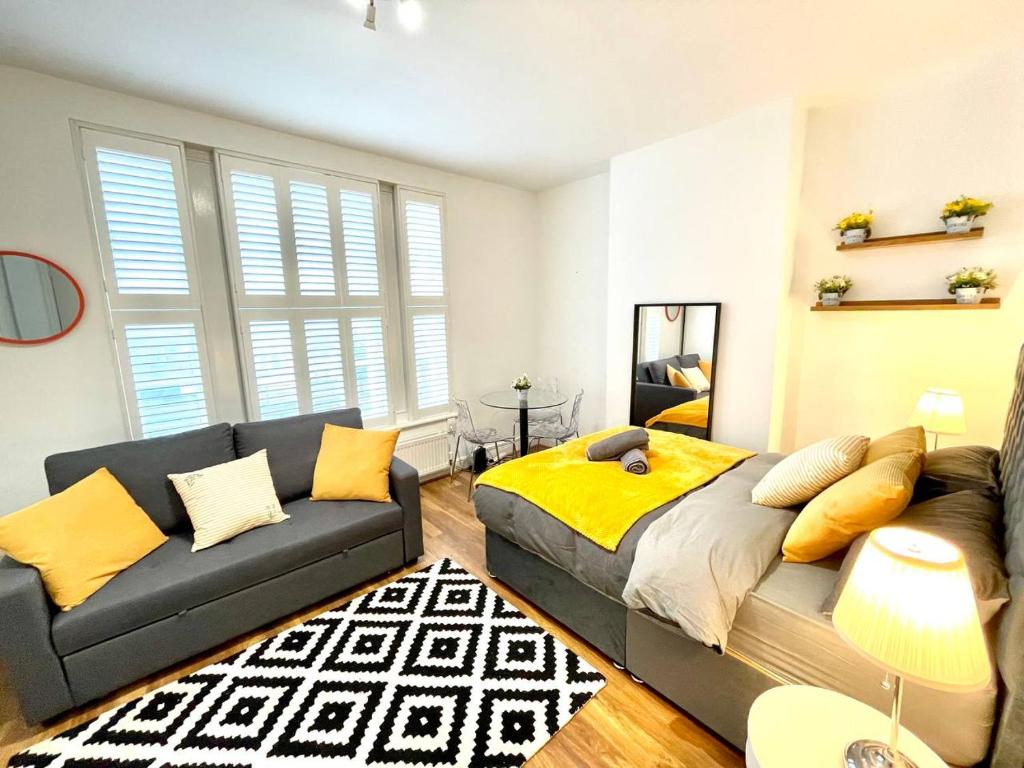 a living room with a bed and a couch at Cosmopolitan Stays in London
