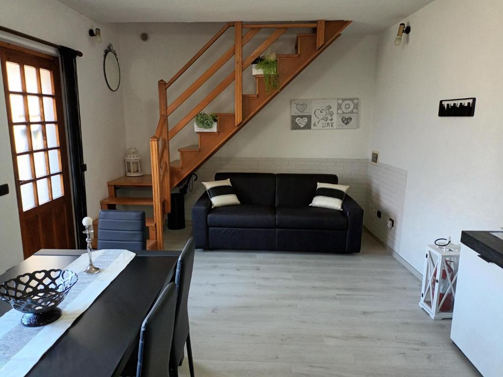 salon z czarną kanapą i schodami w obiekcie Maison de Denise w mieście Lezzeno