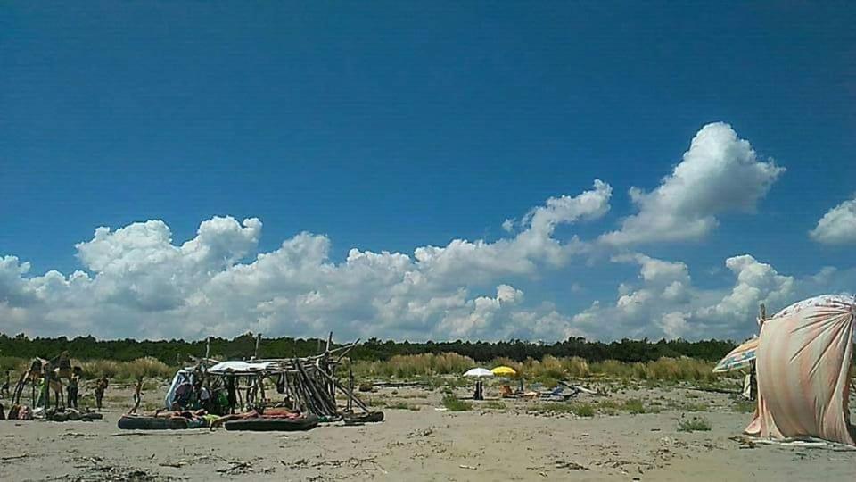 un gruppo di tende su una spiaggia con un cielo nuvoloso di Casa Licanio a Bibione