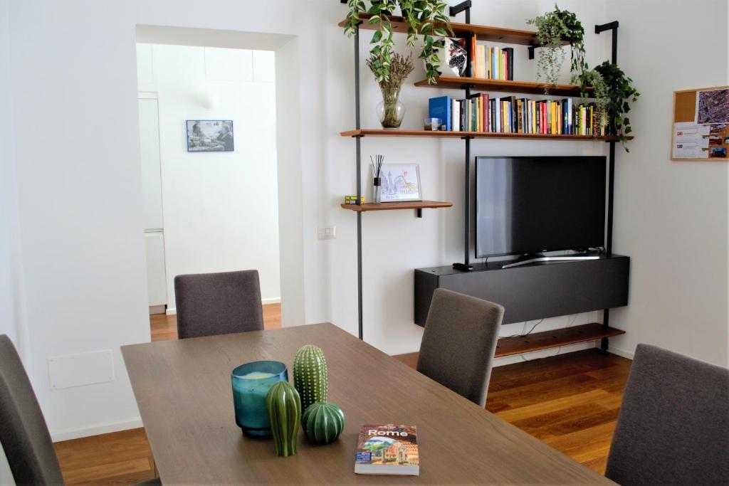 uma sala de jantar com uma mesa e uma televisão em Eternal City Apartment em Roma