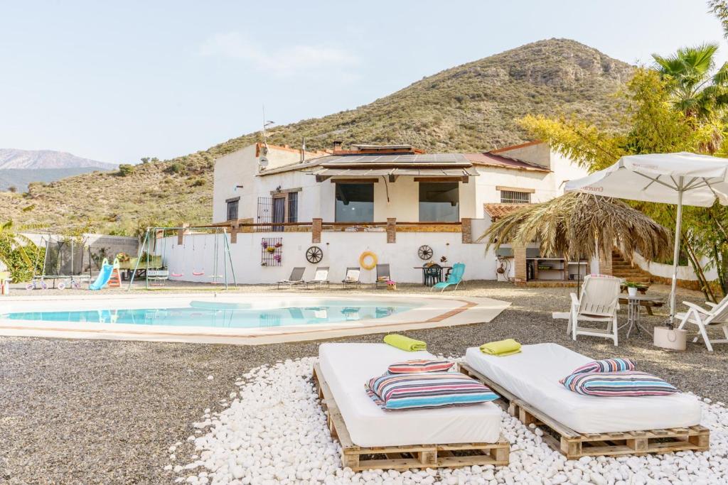 a villa with a swimming pool and a house at CORTIJO OHANA in Motril