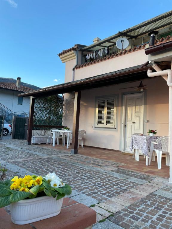 een huis met een patio met een tafel en stoelen bij Casa Vacanze Primavera in Maratea