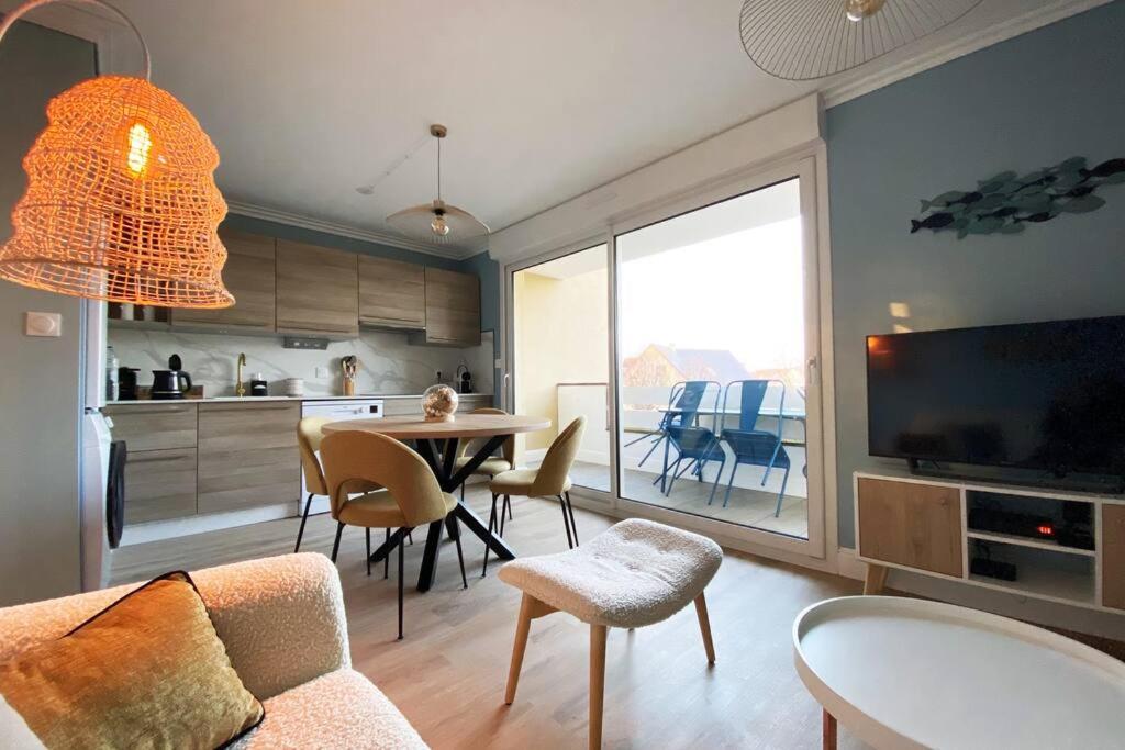 a living room with a couch and a table with chairs at Sainte-Cécile La Cabine Chic 4 personnes in Camiers
