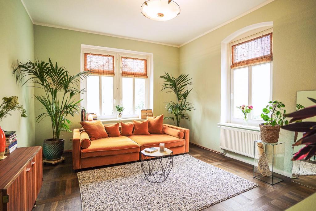 uma sala de estar com um sofá e duas janelas em Ferienwohnung Feel Good Apartment - zentrale 65qm Design Fewo im Zittauer Gebirge - bahnhofsnah in ruhiger Lage em Zittau