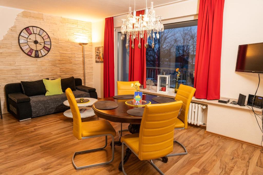 uma sala de estar com uma mesa e cadeiras amarelas em Art City Studio Kassel 3 em Vellmar