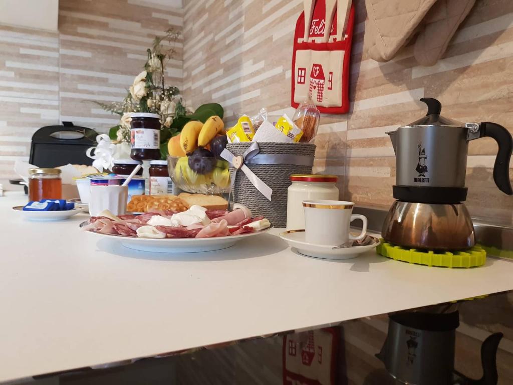 una mesa con un plato de comida y una cafetera en G&E Bed & Breakfast - Austis, en Austis