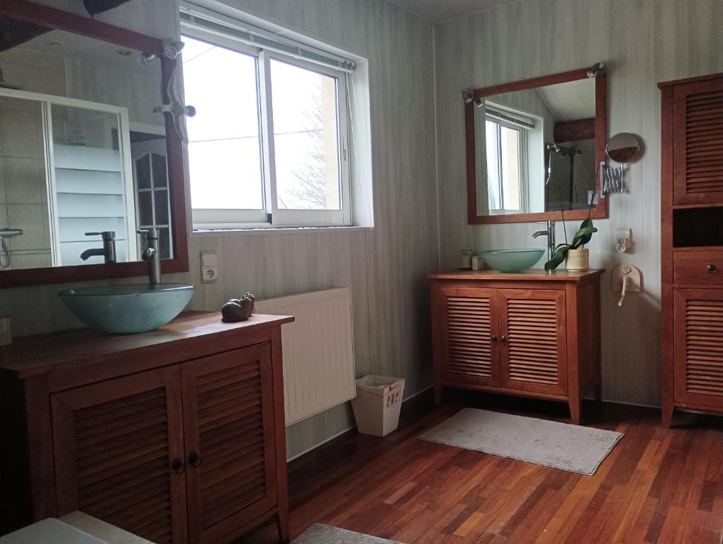 uma casa de banho com dois lavatórios e dois espelhos em Le Marronnier em Saint-Vincent-de-Pertignas