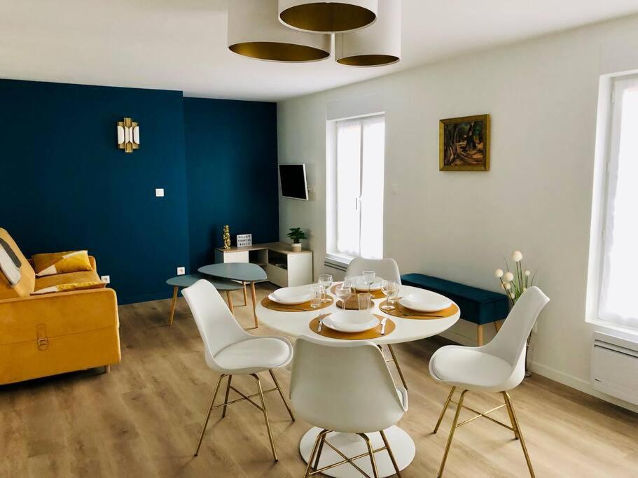 une salle à manger avec une table et des chaises blanches dans l'établissement Maison Gabriel Appartement BULLE, à Abbeville