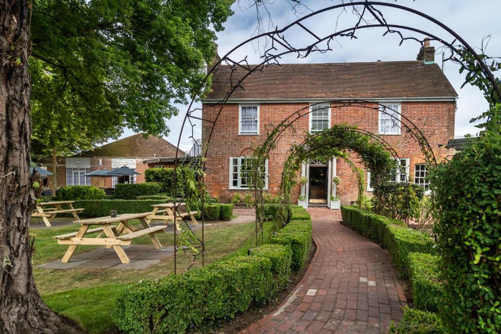 un edificio de ladrillo con una mesa de picnic delante de él en The Bell by Innkeeper's Collection en Aston Clinton