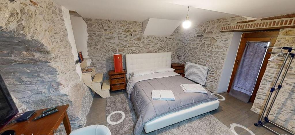San Marco dʼAlunzioにあるBed & Breakfast StudioArcodiaの石壁のベッドルーム1室(ベッド1台付)