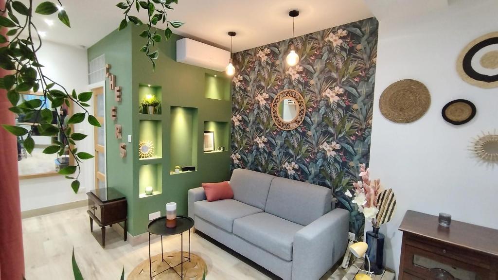 sala de estar con sofá y pared de flores en Studio de charme climatisé Gare Riquier, en Niza