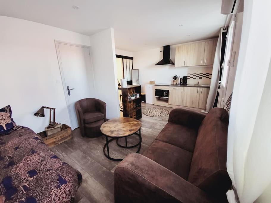 a living room with a couch and a table at Studio tout confort in Blaye-les-Mines