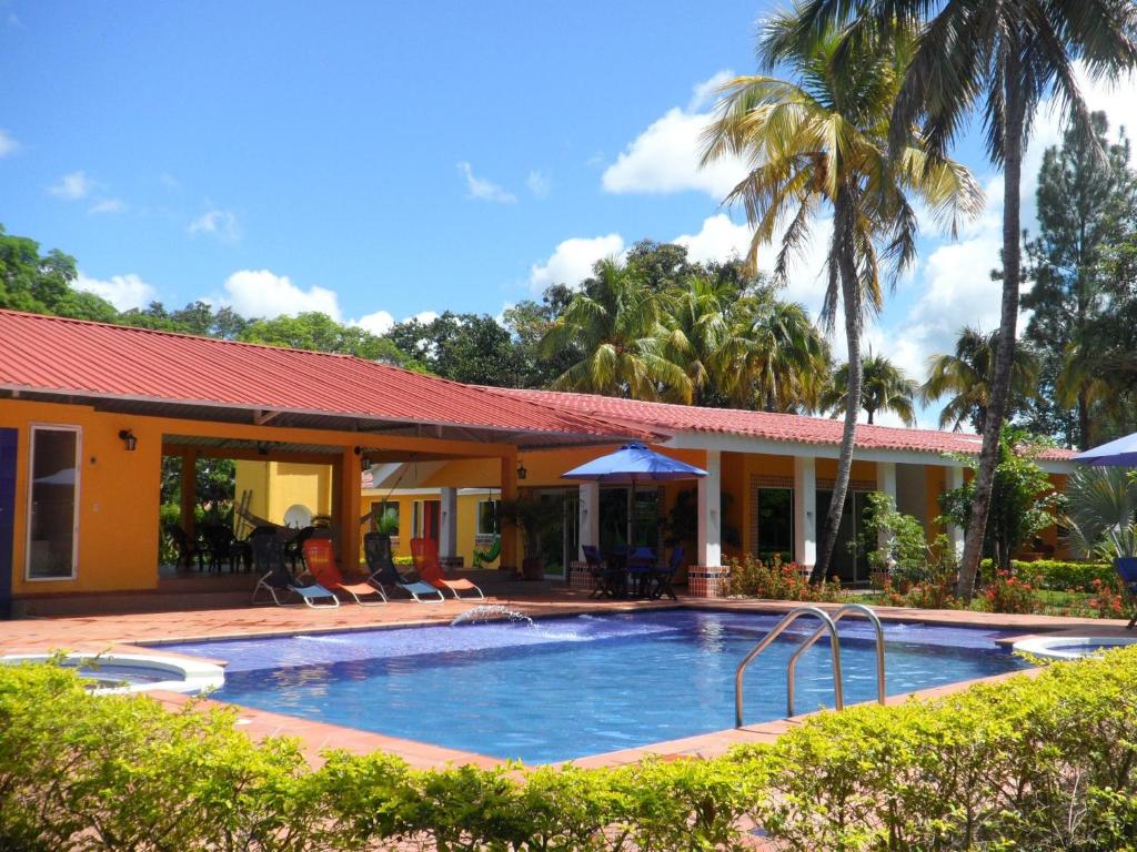 basen przed domem z palmami w obiekcie Finca Villa juanes w mieście Villavicencio