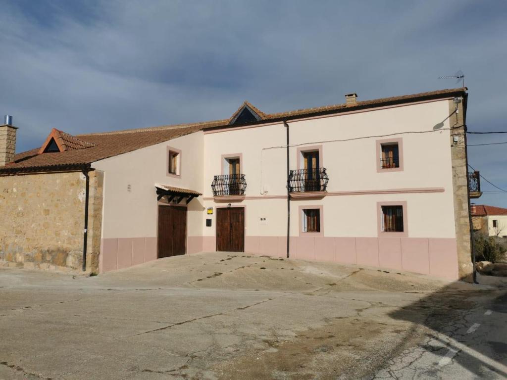 un gran edificio blanco con 2 puertas y entrada en CASA RURAL, con Jacuzzi, Chimenea, BBQ, Bar y mucho mas en Almazán