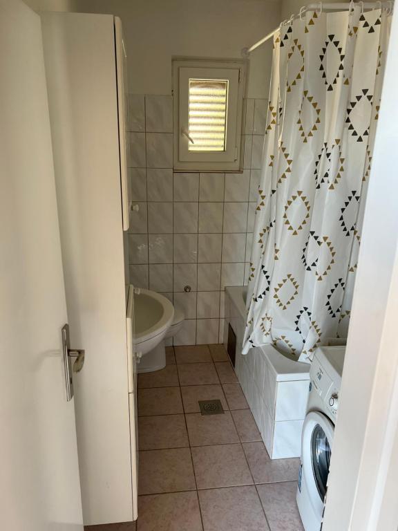 a bathroom with a tub and a shower curtain at Apartment Ivanka in Senj