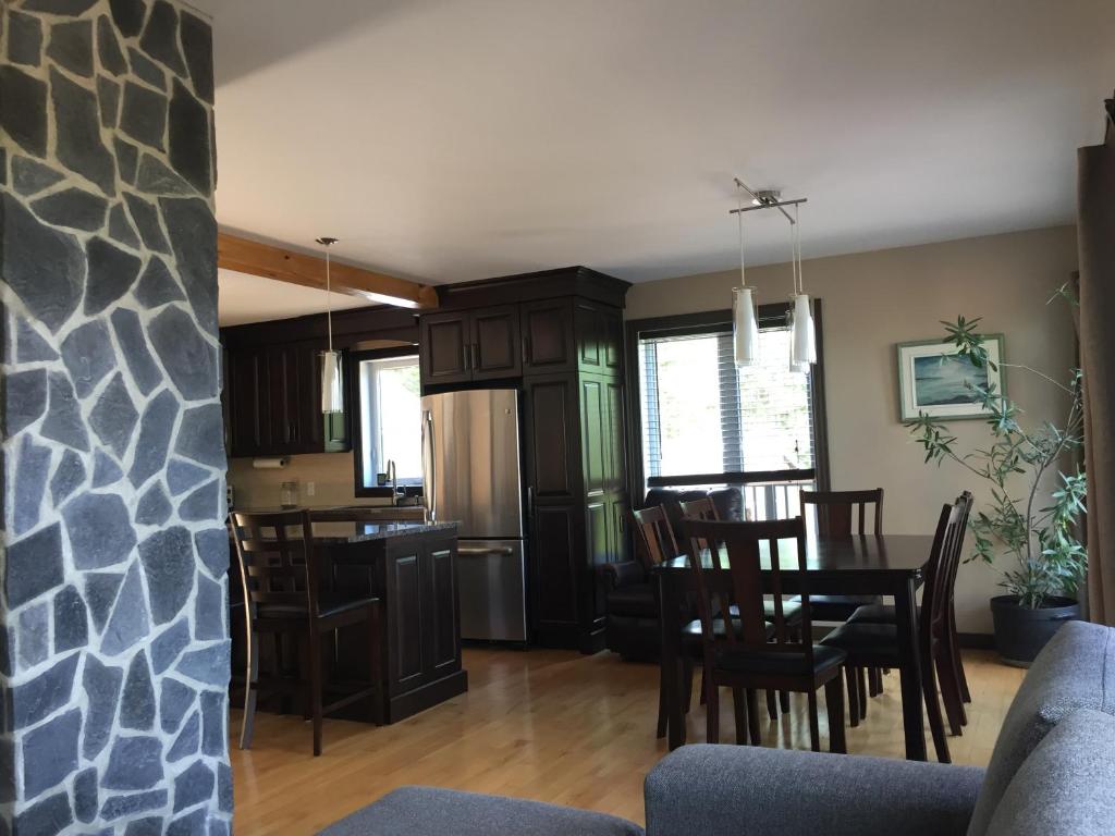 a kitchen and living room with a table and chairs at Les terrasses st aimé in Saint Aime Des Lacs