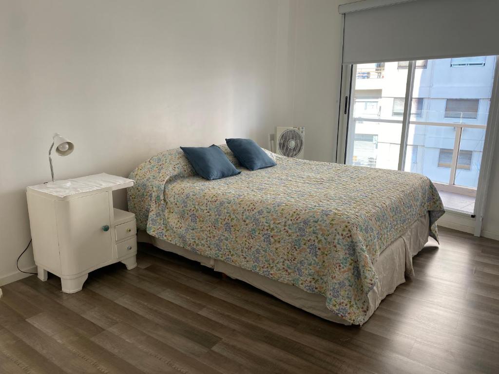 1 dormitorio con 1 cama con almohadas azules y mesita de noche en Piso exclusivo en excelente ubicación en Rosario