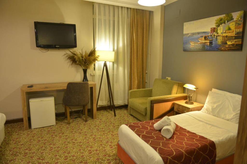 a hotel room with a bed and a desk and a television at Bolu Elit Place in Bolu