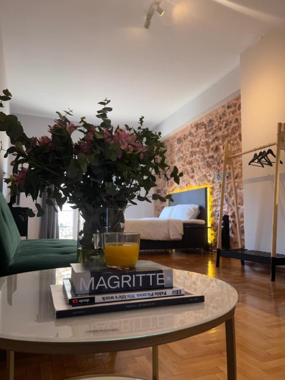 a living room with a table with a book and flowers at Omega54 City Suites Athens Central Business District in Athens