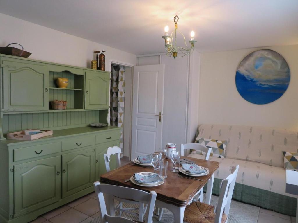 jadalnia z zielonymi szafkami i stołem w obiekcie Le Gîte des Coloriés w mieście Salies-de-Béarn