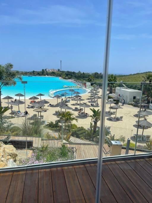 widok na basen z krzesłami i plażę w obiekcie Alcazaba Blue Lagoon 3 bedroom, Ground floor Apartment w mieście Estepona