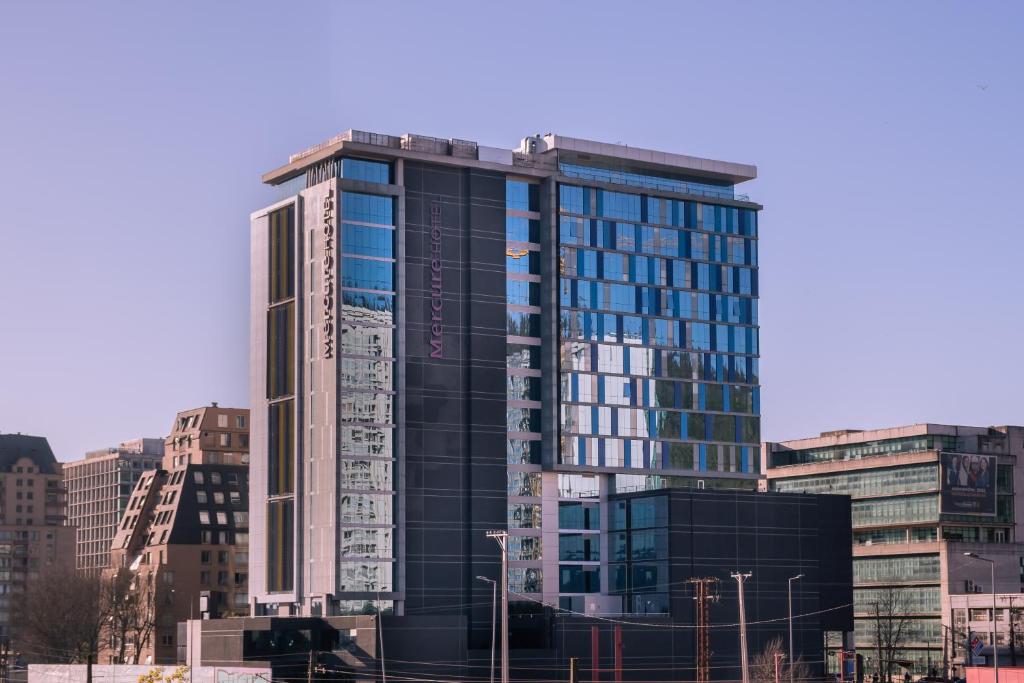 un edificio alto con ventanas de cristal en una ciudad en Mercure Concepcion, en Concepción