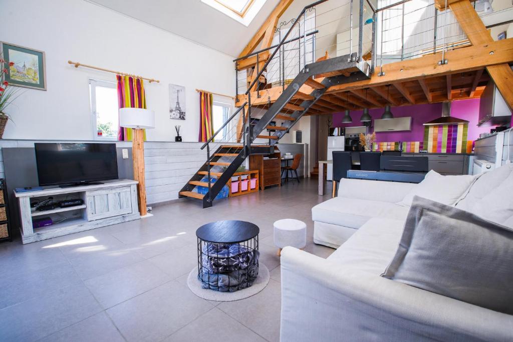 ein Wohnzimmer mit einem weißen Sofa und einem TV in der Unterkunft Gîte du Maupelin tout confort Full équipé pour 4 personnes in Namur
