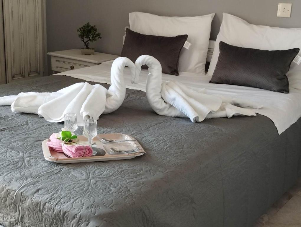 dois cisnes feitos de toalhas numa cama em ALKMENE STUDIOS em Skiathos