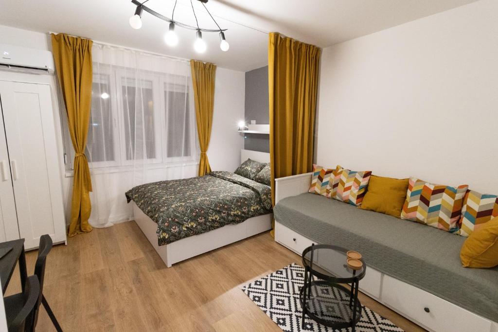 Un dormitorio con sofá y cama. en Harmony apartman, en Donji Milanovac