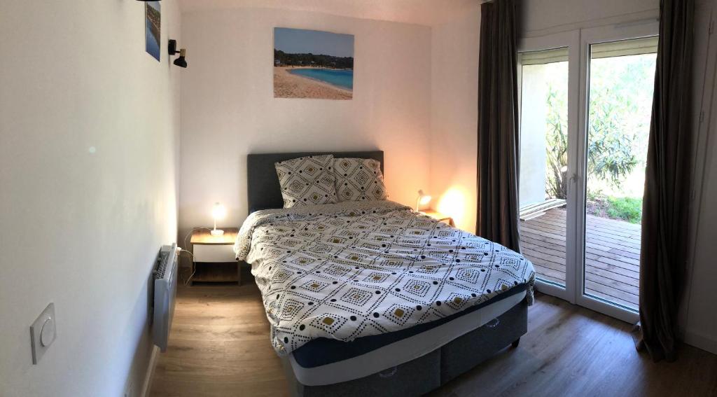 a bedroom with a bed and a large window at Résidence Fiori di Cala Rossa in Lecci
