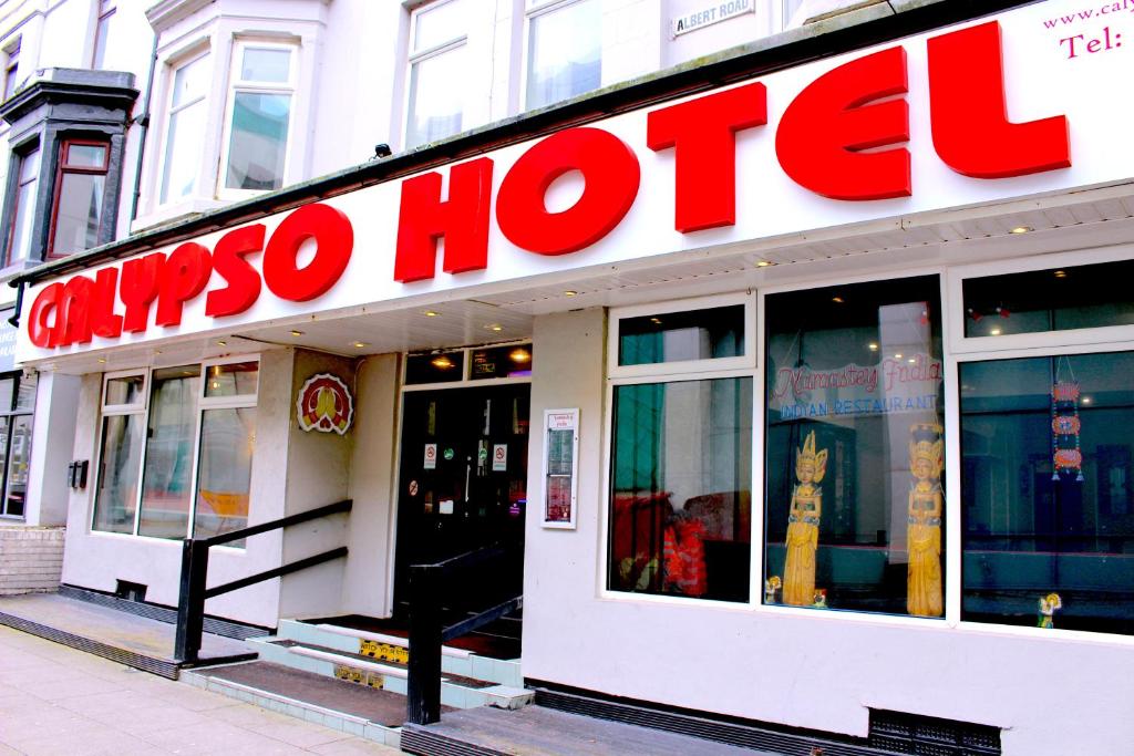 un magasin avec un panneau rouge sur le côté d'un bâtiment dans l'établissement Calypso hotel Blackpool, à Blackpool
