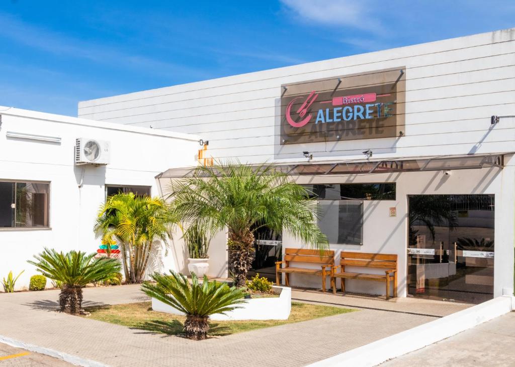 a fast food restaurant with palm trees outside of it at Hotel Alegrete in Alegrete